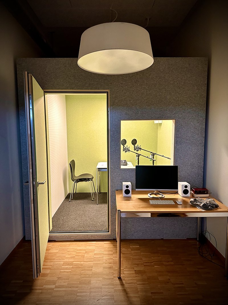 The phonetics lab: a sound-treated recording booth with microphones, and a desk with computer and speakers in front of it